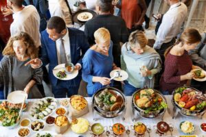 Professional corporate event catering buffet with guests enjoying freshly prepared food and live service by expert caterers