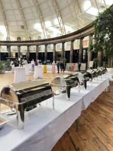 Professional buffet catering setup with stainless steel chafing dishes at an elegant event hall